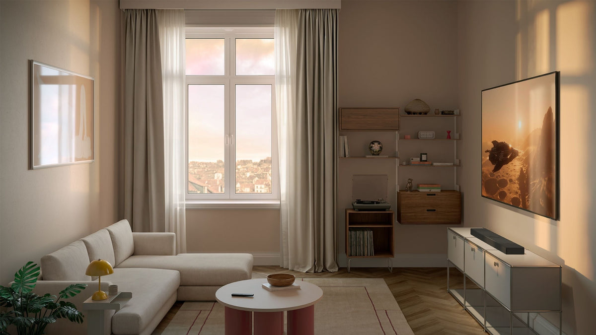 A living room setup with a comfortable sofa, a stylish coffee table, and a television beneath there's KEF XIO Sound bar